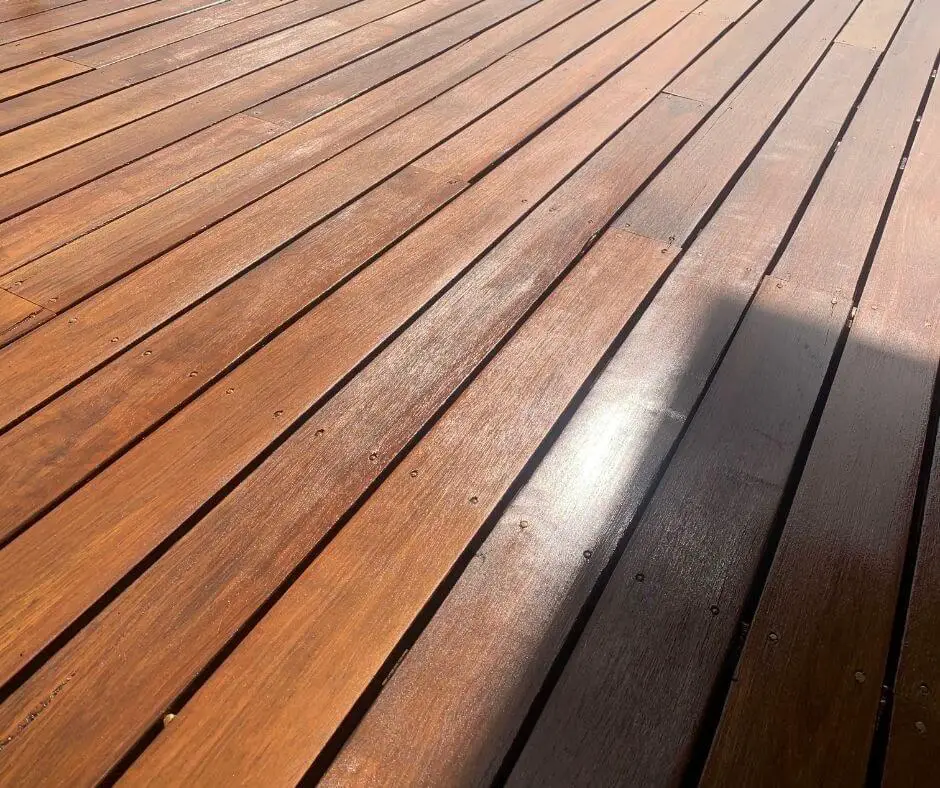 Close-up view of a wooden deck with polished, evenly spaced planks and a shadow cast on the right side.